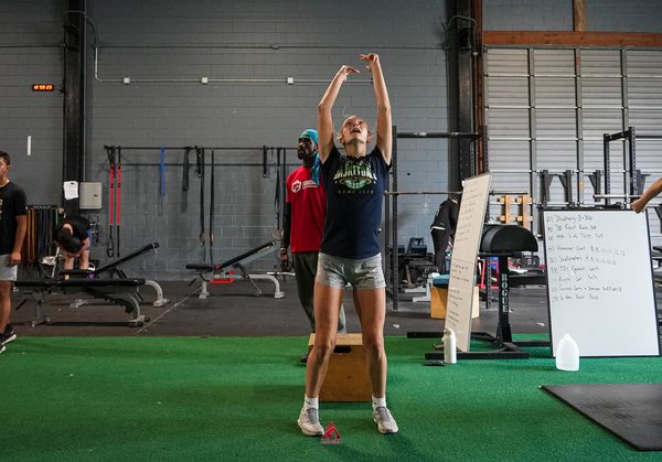 An athlete reaching at the top of a vertical jump test during an assessment at Athletes Acceleration